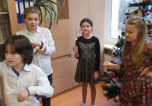 Uczennice stoją w kręgu, odpalając zimne ognie.