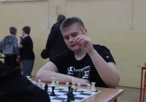Uczeń wykonuje ruch na szachownicy.