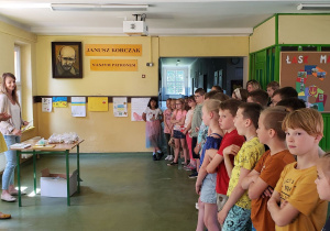 Dzieci z młodszych klas zgromadzeni na korytarzu szkolnym oczekują na rozstrzygnięcie konkursu na kapliczkę dla Matki Bożej.