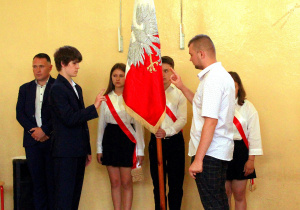 Przedstawiciele klasy ósmej ślubują uroczyście w obecności sztandaru szkolnego.