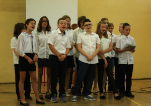 Uczniowie klasy piątej śpiewają piosenkę.