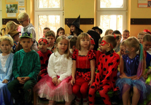 Dzieci ubrane w stroje swoich ulubionych postaci z bajek siedzą na widowni.