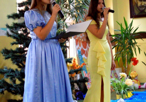 Uczennice w strojach księżniczek śpiewają popularną piosenkę przed widownią.