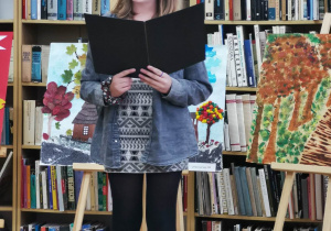 Uczennica czytająca wiersz o Łasku.