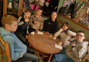 Uczniowie przy stoliku podczas poczęstunku w Baśniowej Kawiarence.