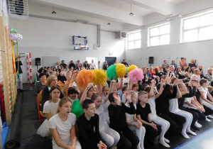 Społeczność szkolna wraz z gośćmi na widowni podczas uroczystego otwarcia sali gimnastycznej.