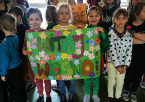 Uczennice klasy pierwszej prezentują plakat na powitanie wiosny.