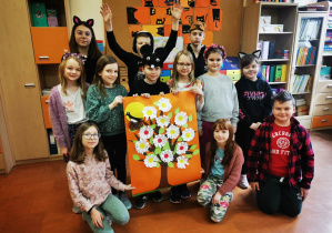 Uczniowie klasy trzeciej prezentują plakat na powitanie wiosny.