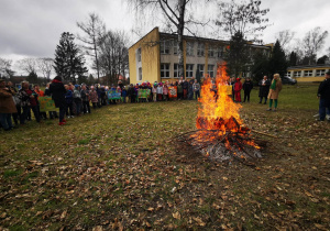 Uczniowie przyglądają się Marzannie palonej w ognisku.