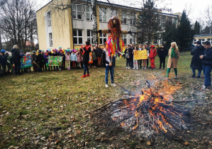 Uczniowie przyglądają się Marzannie palonej w ognisku.