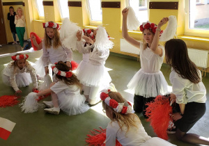 Uczennice prezentują taniec w strojach biało czerwonych podczas apelu z okazji 3 Maja.