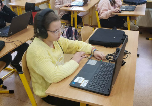 Uczennica przy komputerze rozwiązuje zadania konkursowe.