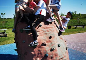 Uczniowie klasy czwartej na skałce wspinaczkowej na skateparku.