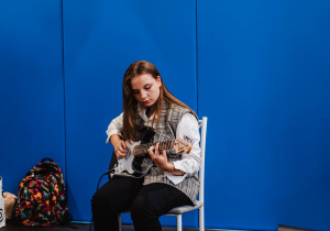 Uczennica klasy ósmej podczas gry na gitarze.