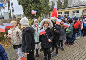 Dzieci gromadzą się przed budynkiem szkoły, aby wyruszyć na marsz z okazji Święta 11 listopada.