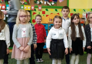 Uczniowie klasy przedszkolnej podczas przedstawienie dla goszczących w klasie babć i dziadków.
