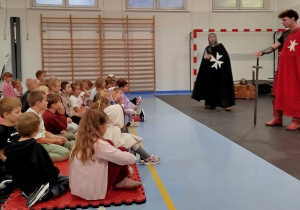 Dzieci słuchają opowieści dwóch rycerzy.