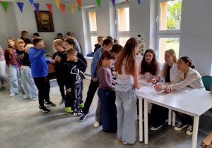 Uczniowie komisji wyborczej nadzorują proces głosowania i sprawdzają listę osób biorących udział w wyborach.