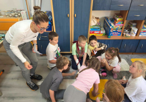 Uczniowie pracują w małej grupie, wykonując zadanie edukacyjne z wykorzystaniem kart obrazkowych.