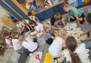 Uczestnicy zajęć współpracują przy rozwiązywaniu zadania pod opieką prowadzącej, rozwijając wiedzę o zdrowych nawykach żywieniowych.