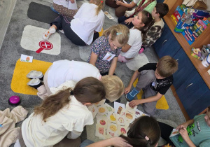 Uczestnicy zajęć współpracują przy rozwiązywaniu zadania pod opieką prowadzącej, rozwijając wiedzę o zdrowych nawykach żywieniowych.