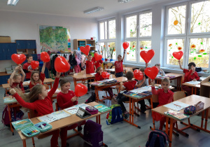 Dzień bez Przemocy. Dzieci ubrane na czerwono trzymają w dłoniach czerwone balony.