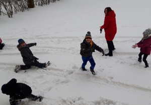 Dzieci bawiące się na śniegu.