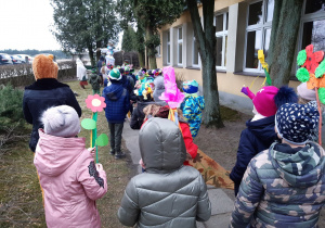 Dzieci idą w wiosennym korowodzie.
