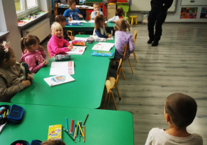 Uczniowie klasy przedszkolnej słuchają wystąpienia pani policjantki.