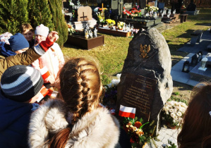 Uczniowie klasy 5 wraz z opiekunami gromadzą się przy pomniku poświęconym wszystkim walczącym o niepodłegość Polski.