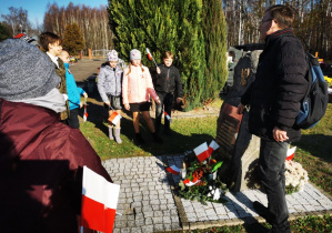 Uczniowie klasy 5 wraz z opiekunami gromadzą się przy pomniku poświęconym wszystkim walczącym o niepodłegość Polski.