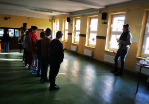 Grupa uczniów na szkolnym korytarzu podczas apelu podsumowującego szkolny dzień bez przemocy.