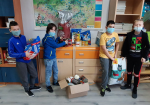 Grupka chłopców segreguje karmę zebraną podczas akcji Paka dla Zwierzaka.